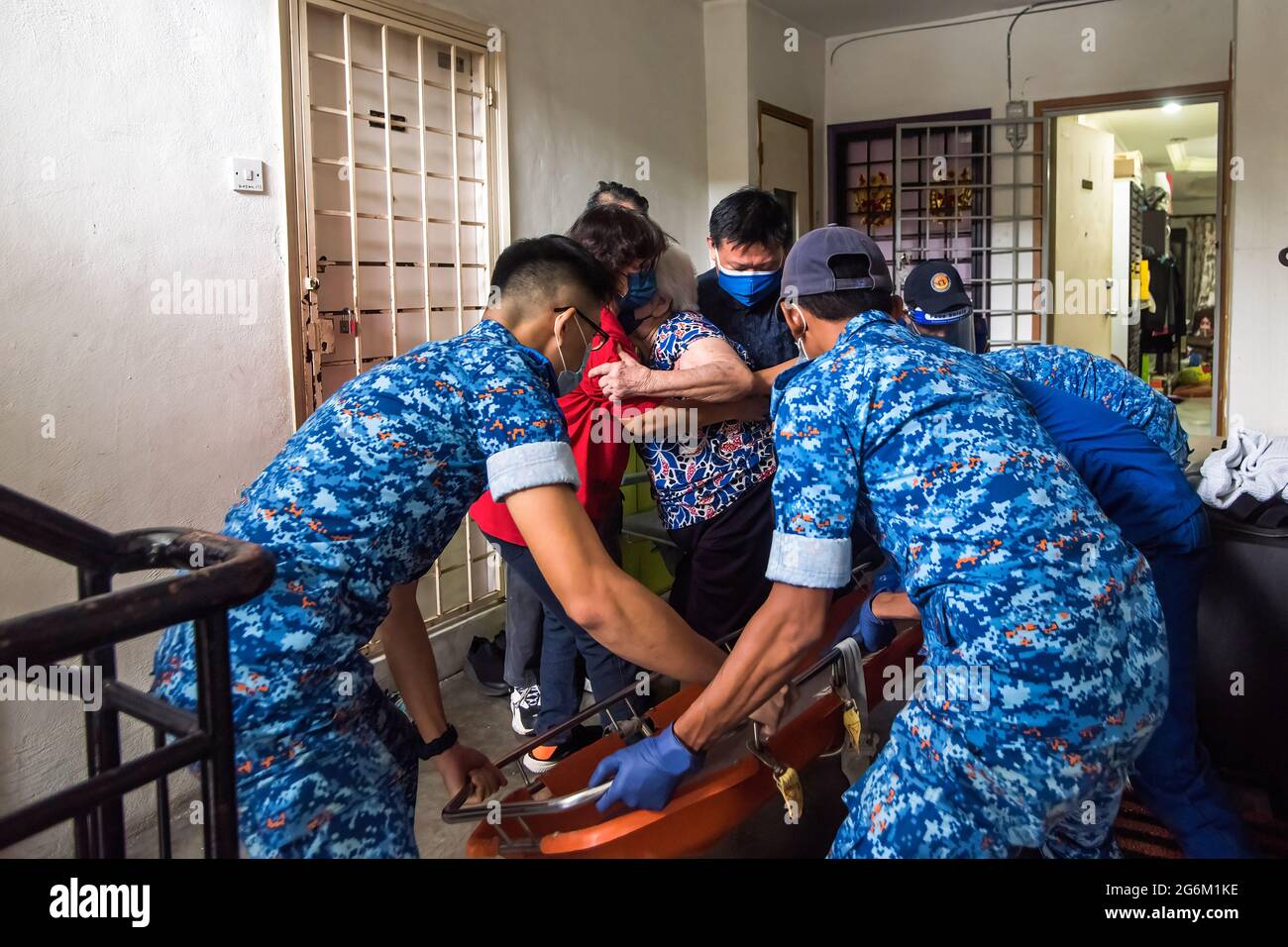 Kuala Lumpur, Malesia. 05 luglio 2021. Una donna aiuta la donna di 86 anni con problemi di mobilità su una barella con il personale della Malaysia Civil Defense Force pronto a trasferirla in ambulanza. Il governo malese ha dichiarato che circa il 79.2% degli anziani che si sono registrati per il vaccino hanno ricevuto almeno una dose, il programma mira a completare le vaccinazioni per gli anziani registrati entro la fine di luglio 2021. Credit: SOPA Images Limited/Alamy Live News Foto Stock