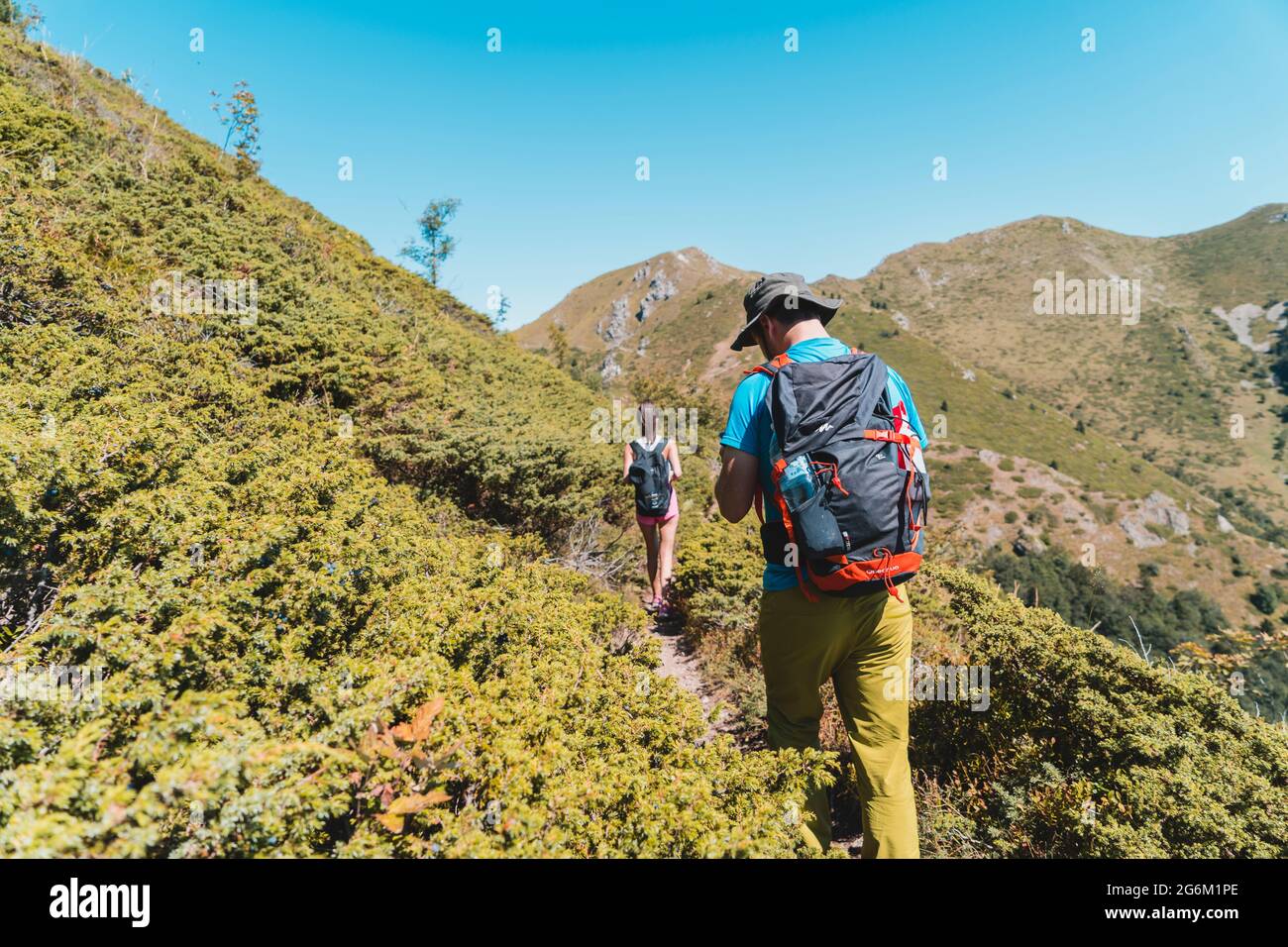 Escursionisti a piedi su sentiero di montagna nei cespugli Foto Stock