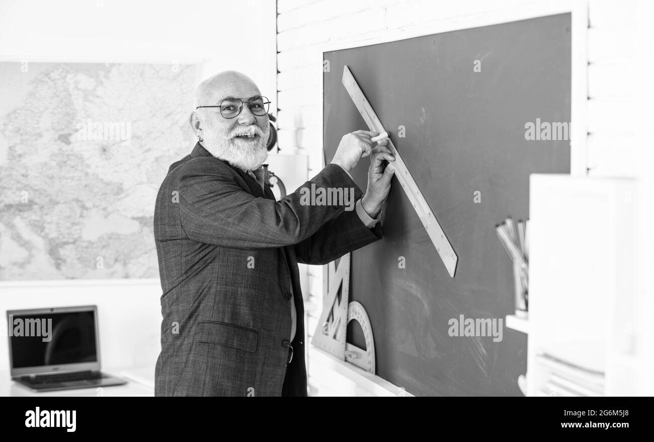 allenarsi nel tempo. tutor uomo in occhiali disegnare con righello su lavagna. torna a scuola. che angolo si guarda. forme geometriche. scuola superiore moderna Foto Stock