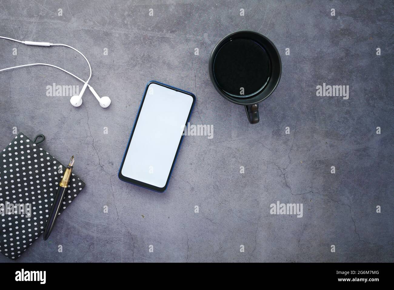 vista dall'alto dello smartphone e dell'auricolare sul tavolo Foto Stock