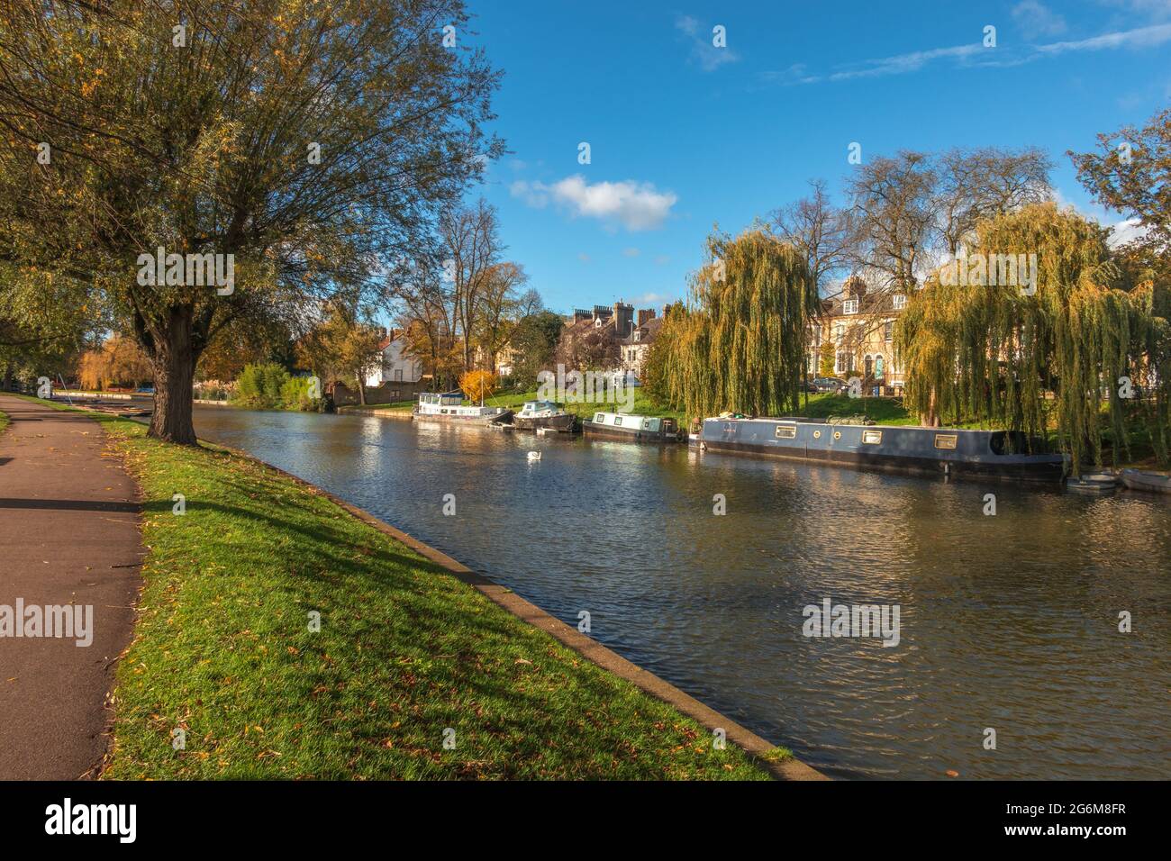 Bella vista sul fiume Cam a Cambridge Inghilterra con le case lungo il fiume e le barche ormeggiate lungo la riva fiancheggiata da salici su ha Foto Stock