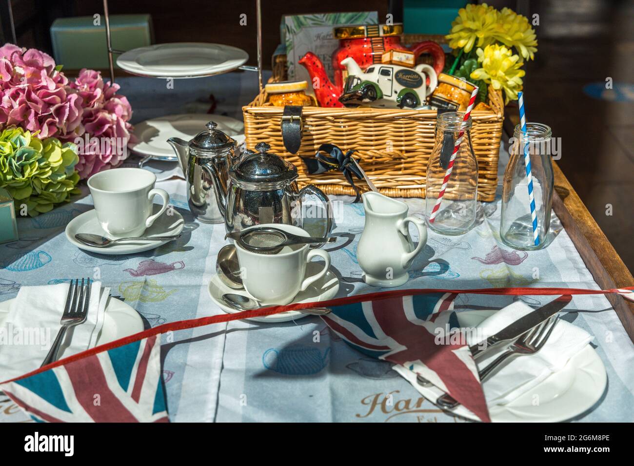 Esposizione britannica del tè con tazze, battitori di teapots e bandiere di Unione Foto Stock