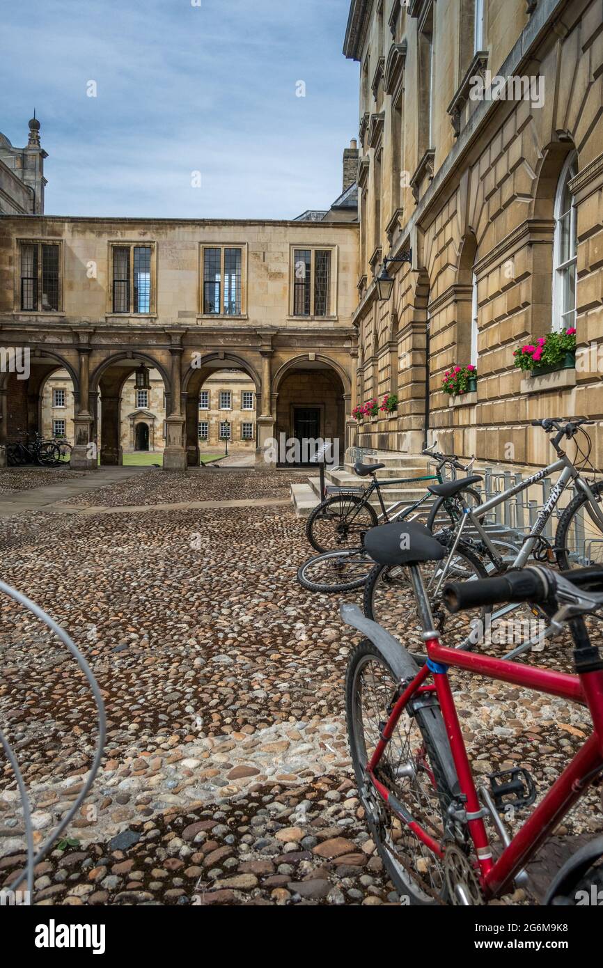 First Court of Peterhouse College University of Cambridge con passerella ad arco con gallerie sopra e cicli in primo piano su terreno acciottolato. Foto Stock
