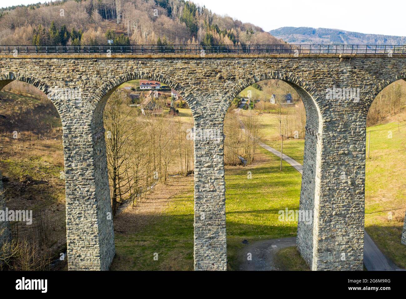 Vista aerea del ponte ad arco viadotto vicino al piccolo villaggio nella foresta. Foto Stock