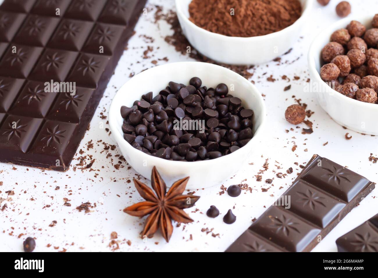 Ciotola di ciotole o gocce di cioccolato con ingredienti da dessert su  tavola bianca Foto stock - Alamy