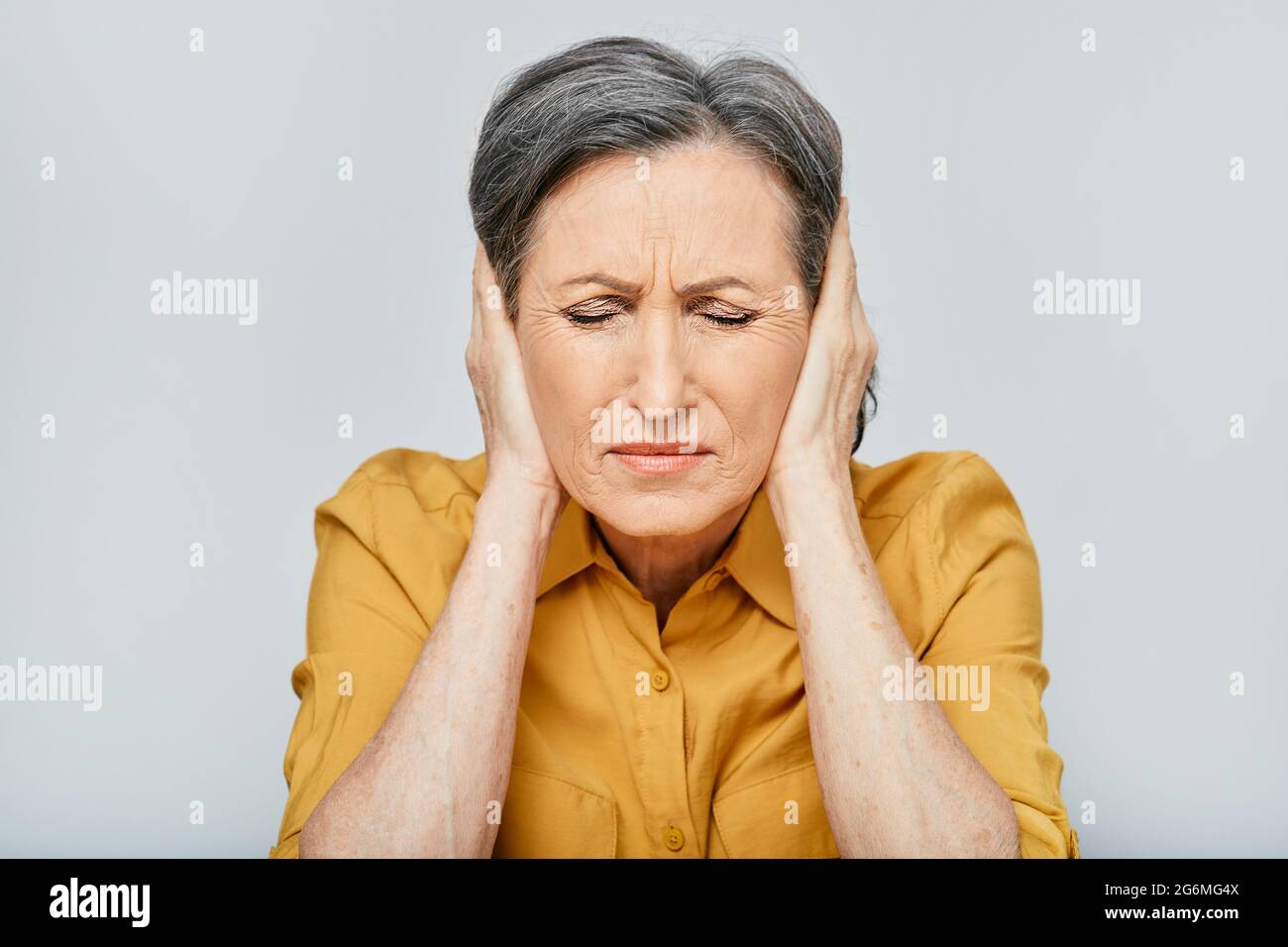 Mal di testa, stress. Donna matura con mal di testa che tocca le mani sui templi con viso sofferente e occhi chiusi. Emicrania Foto Stock