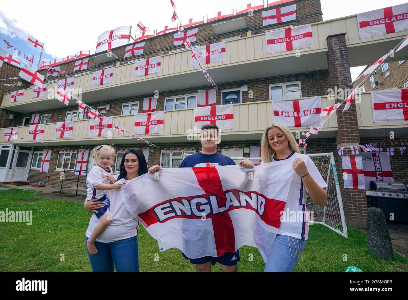 (Da sinistra a destra) due anni Dollie (cognome non dato), Jade Brooks, Lewis Hickey e China Collis , alcuni dei residenti di Towfield Court a Feltham che hanno trasformato la loro proprietà con bandiere inglesi per il torneo Euro 2020. Data immagine: Mercoledì 7 luglio 2021. Foto Stock