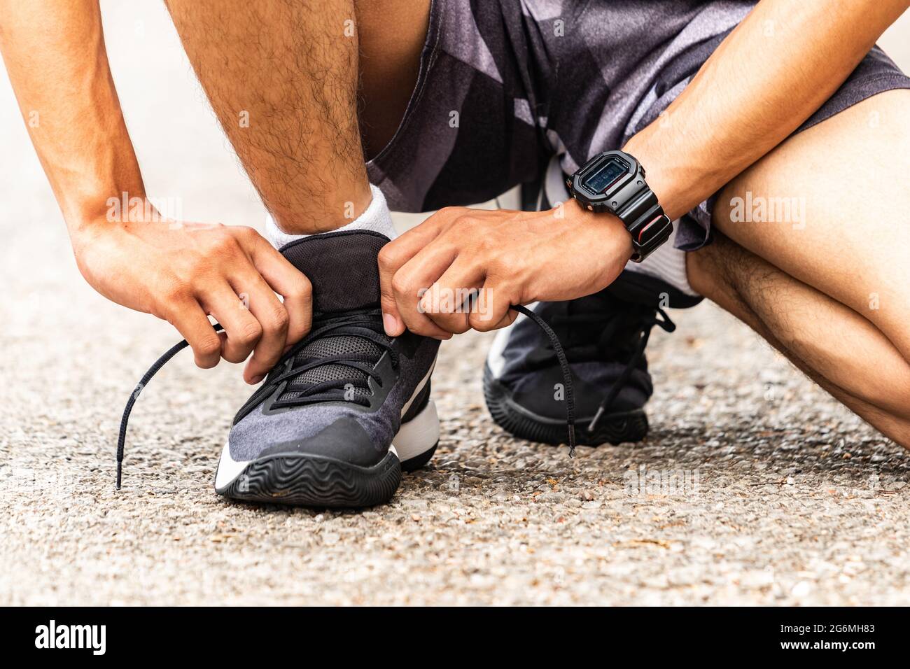 I corridori stanno legando le loro lacci, corre nel parco. Primo piano uomo legando scarpe da jogging. Foto Stock