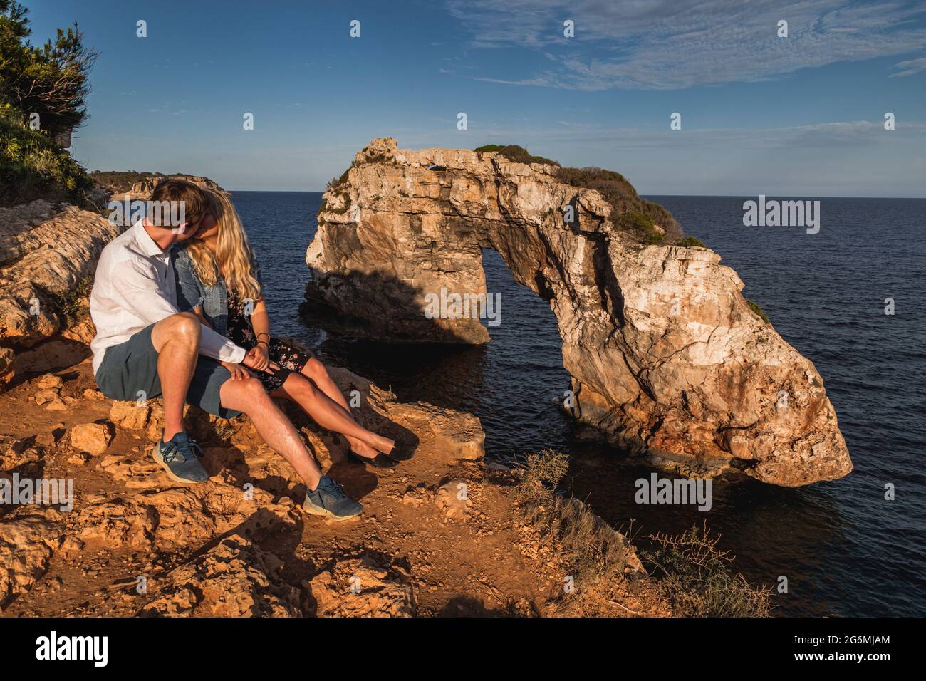 Coppia baciando di fronte a es pontas alla luce della sera Foto Stock