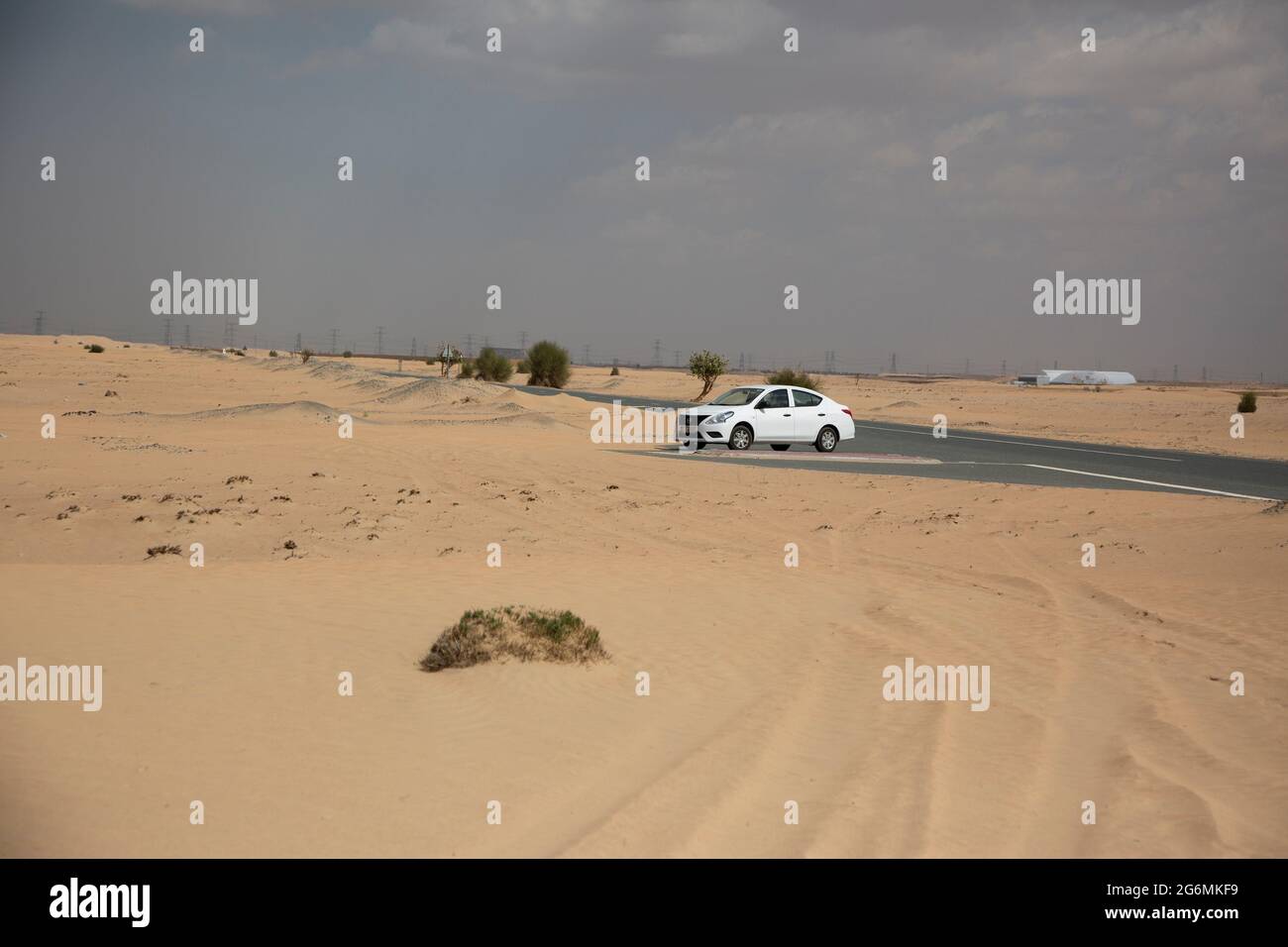 Guida intorno al deserto in un Nissan soleggiato, Dubai, Emirati Arabi Uniti. Foto Stock