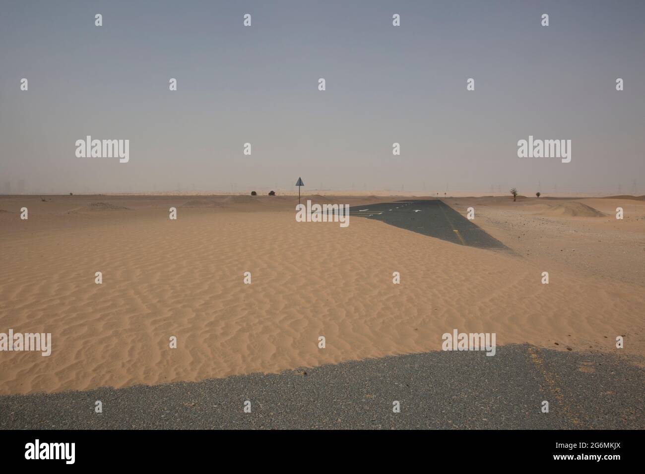 Una strada coperta di sabbia dopo una tempesta di sabbia a Dubai, Emirati Arabi Uniti. Foto Stock