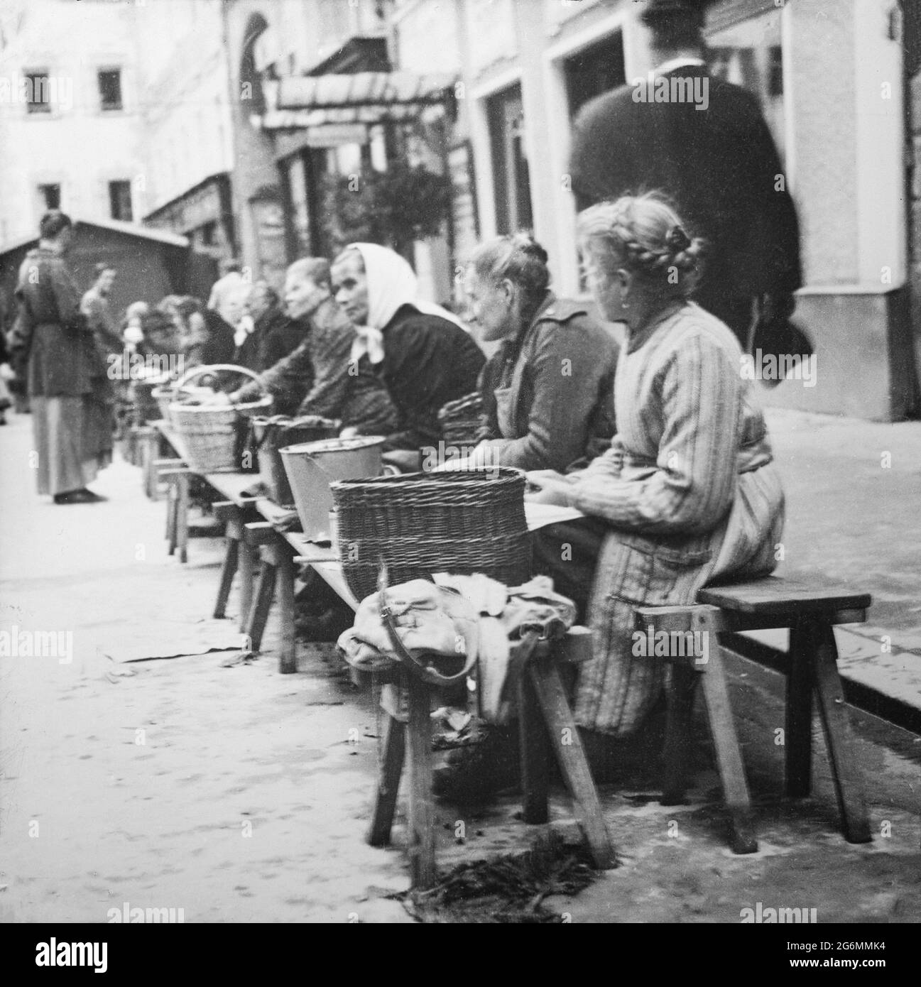 Una fotografia in bianco e nero d'epoca che mostra le donne che vendono merci da cesti di vimini in un mercato a Salisburgo, in Austria. Foto Stock
