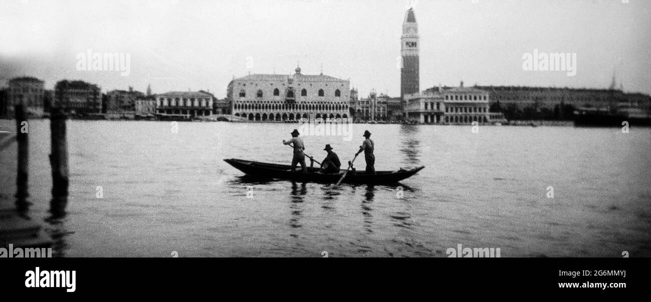 Una fotografia in bianco e nero d'epoca dei primi del XX secolo che mostra un canale a Venezia, con gondolieri in gondola. Foto Stock