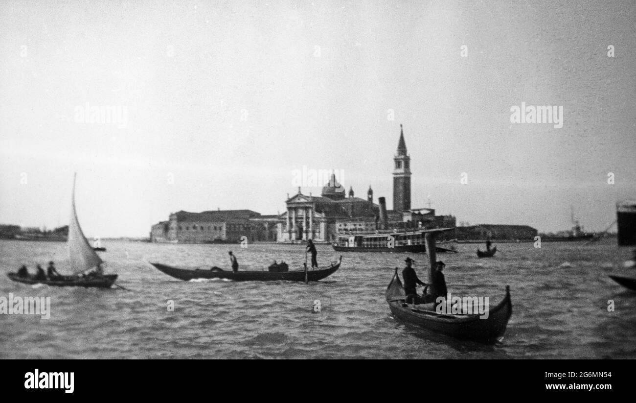 Una fotografia in bianco e nero d'epoca dei primi del XX secolo che mostra un canale a Venezia, con gondolieri in gondola. Foto Stock