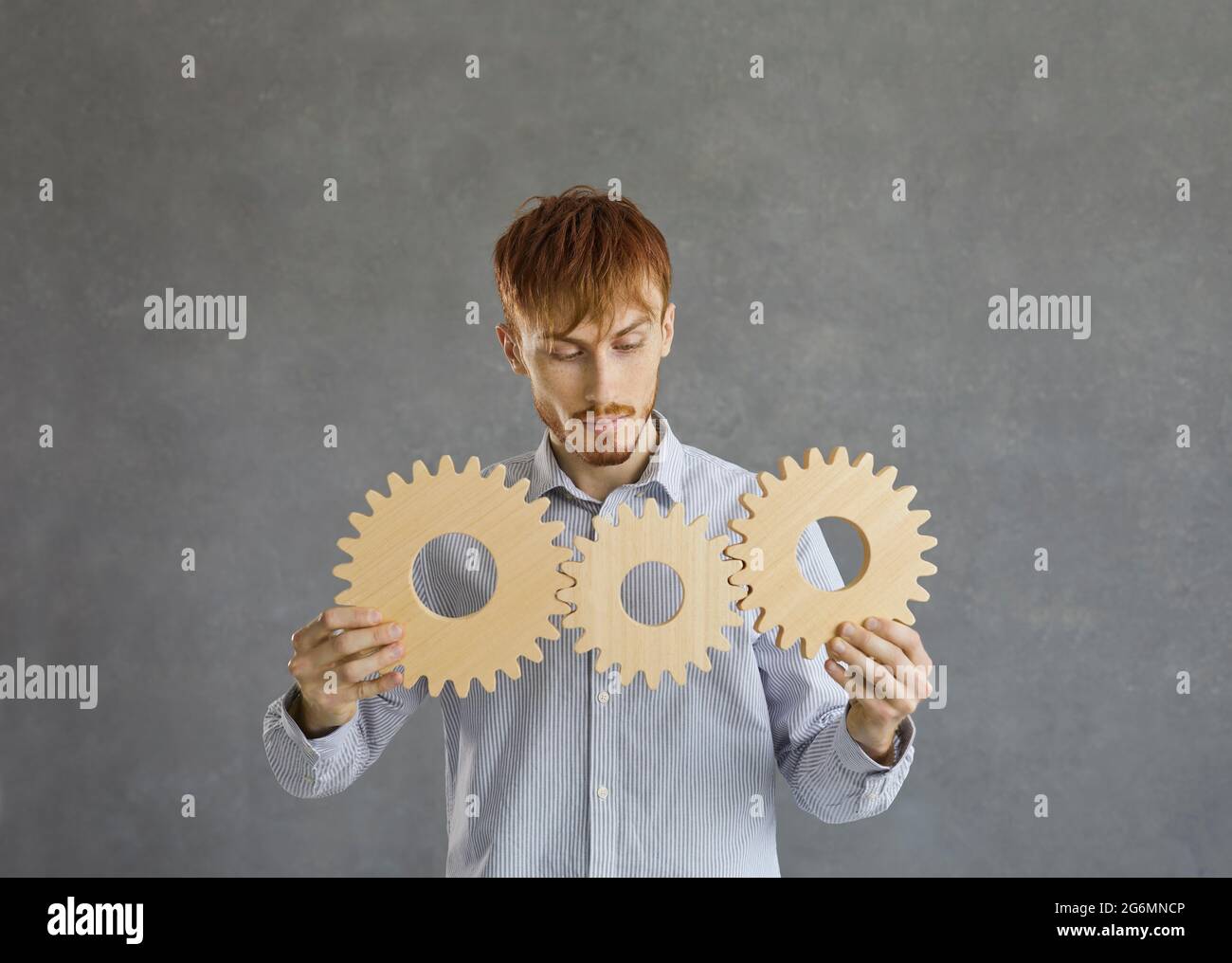 Uomo d'affari che tiene gli ingranaggi e genera le idee. Foto Stock