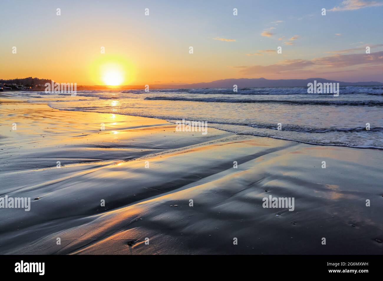 Incredibile alba. Splendida vista sul mare durante l'estate. La sabbia bagnata sulla costa del mare. Paesaggio del mattino. Onde alte con schiuma. Cornice widescreen bac Foto Stock