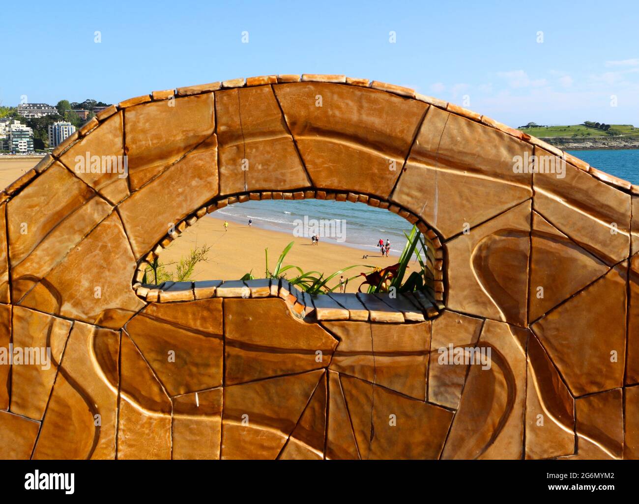 Vista dai Giardini Piquio delle spiagge di Sardinero attraverso un buco nel muro decorativo piastrellato Santander Cantabria Spagna Foto Stock