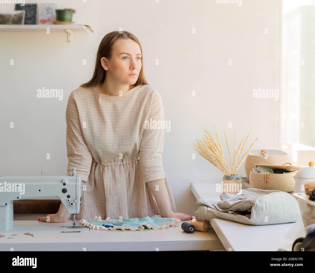 Giovani marinai in piedi vicino al posto di lavoro presso atelier di moda e guardando via con un look attento Foto Stock