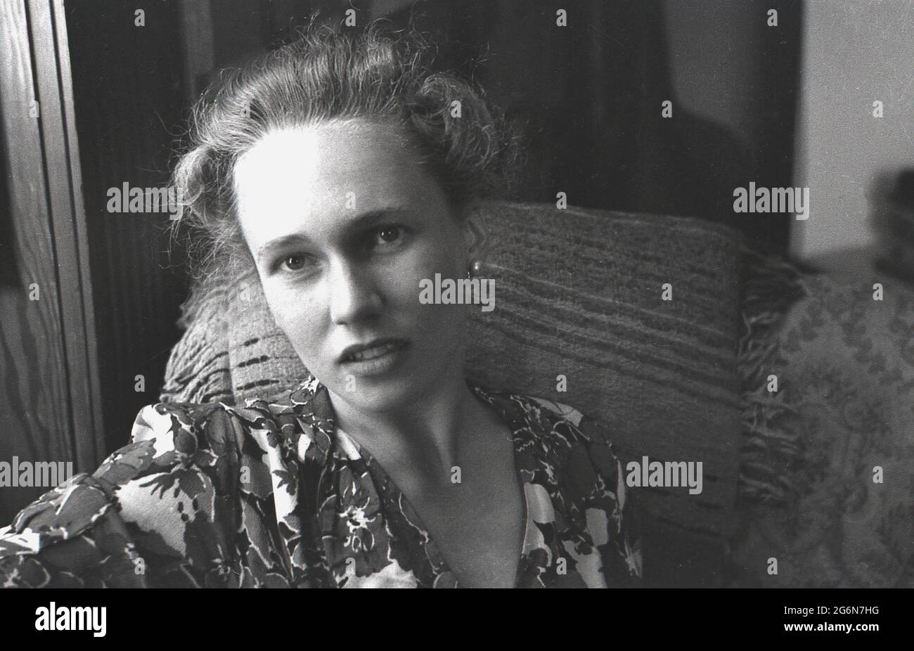 Anni '50, storico, un fronte, primo piano profilo di una giovane signora inglese attraente seduta in una sedia, Inghilterra, Regno Unito. Foto Stock