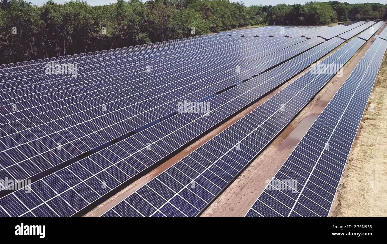 Drone vista ad alto angolo di pannelli di energia solare durante la giornata di sole. Fotovoltaico sistema fotovoltaico in matrice solare di una fattoria solare. Foto Stock
