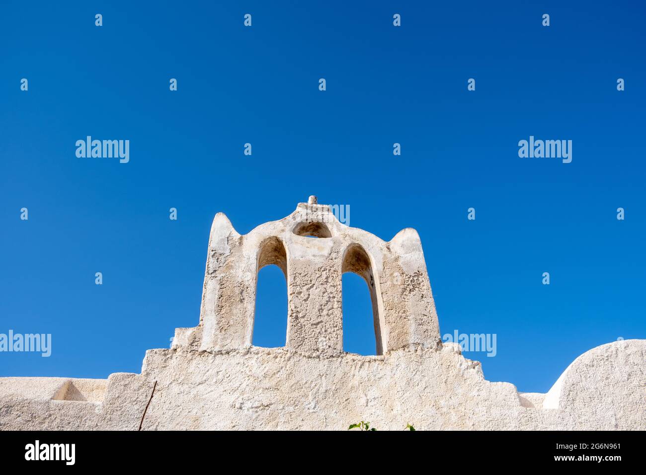 Vecchia chiesa nella parte superiore della città di Chora. Grecia, Cicladi. Isola di FOLEGANDROS, tradizionale cappella delle Cicladi, pareti imbiancate di bianco, cielo blu chiaro sfondo Foto Stock
