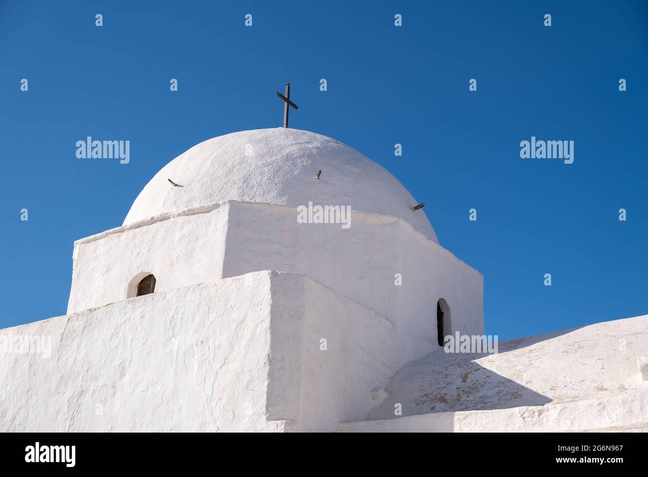 Grecia, Cicladi. Isola di FOLEGANDROS, cupola della vecchia chiesa nella città di Chora. Tradizionale cappella cicladica, pareti bianche, cielo blu chiaro sfondo. Copia s Foto Stock