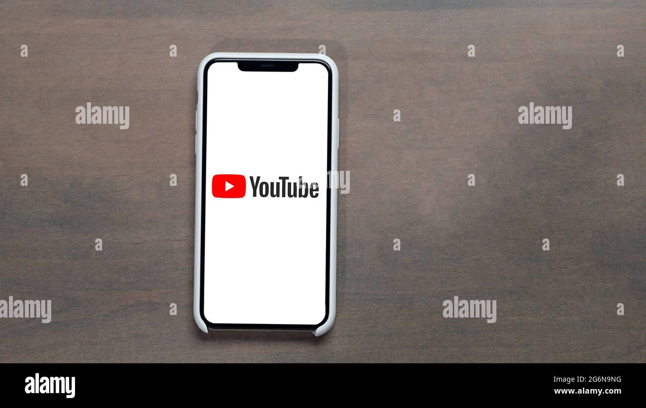 San francisco, USA - 28 febbraio 2020: Smartphone con logo dell'app YouTube su schermo bianco su tavolo di legno con sfondo copy space. Foto Stock