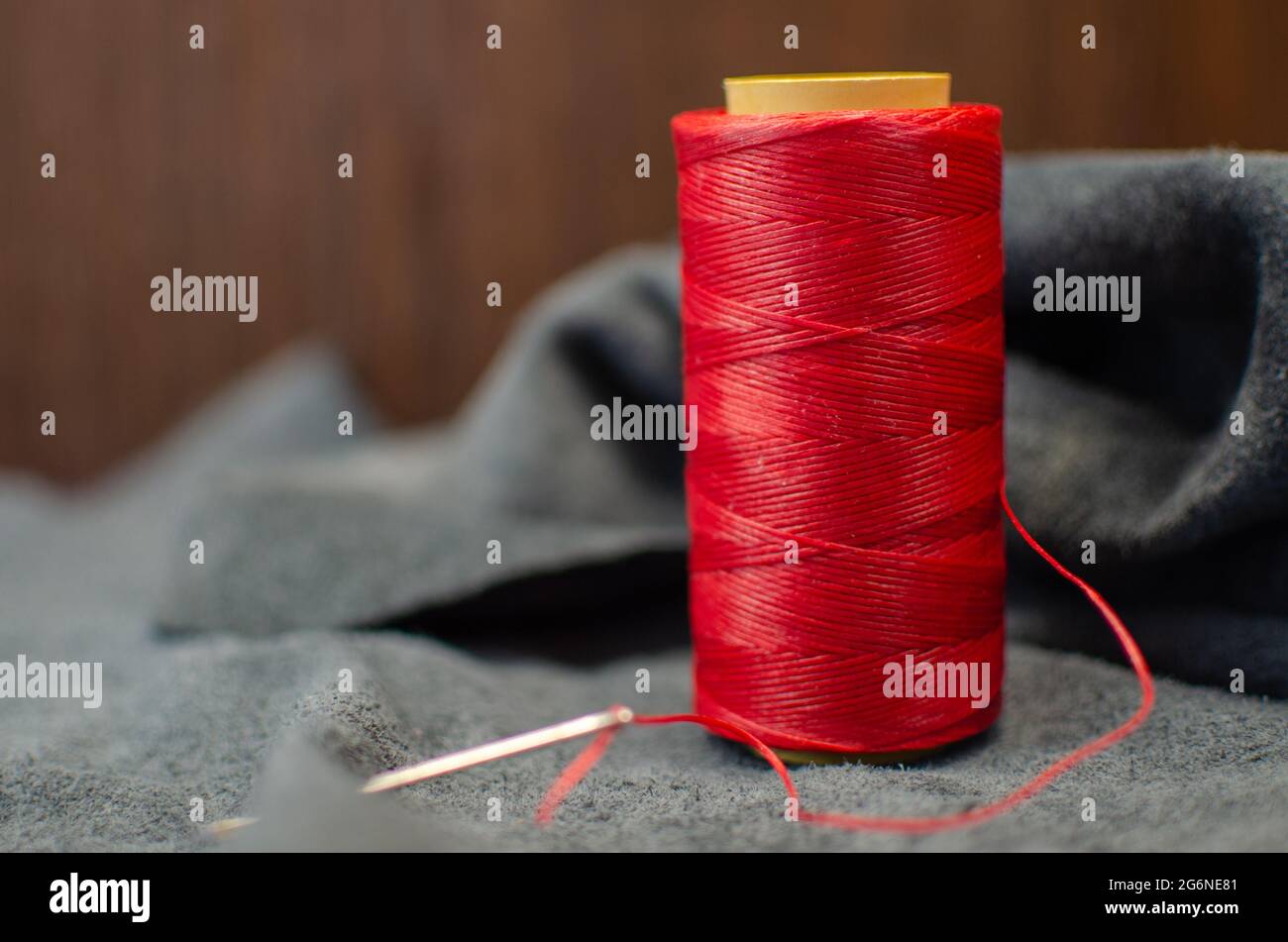 una bobina di filo cerato rosso per cucire il cuoio. Su sfondo in pelle  nera Foto stock - Alamy