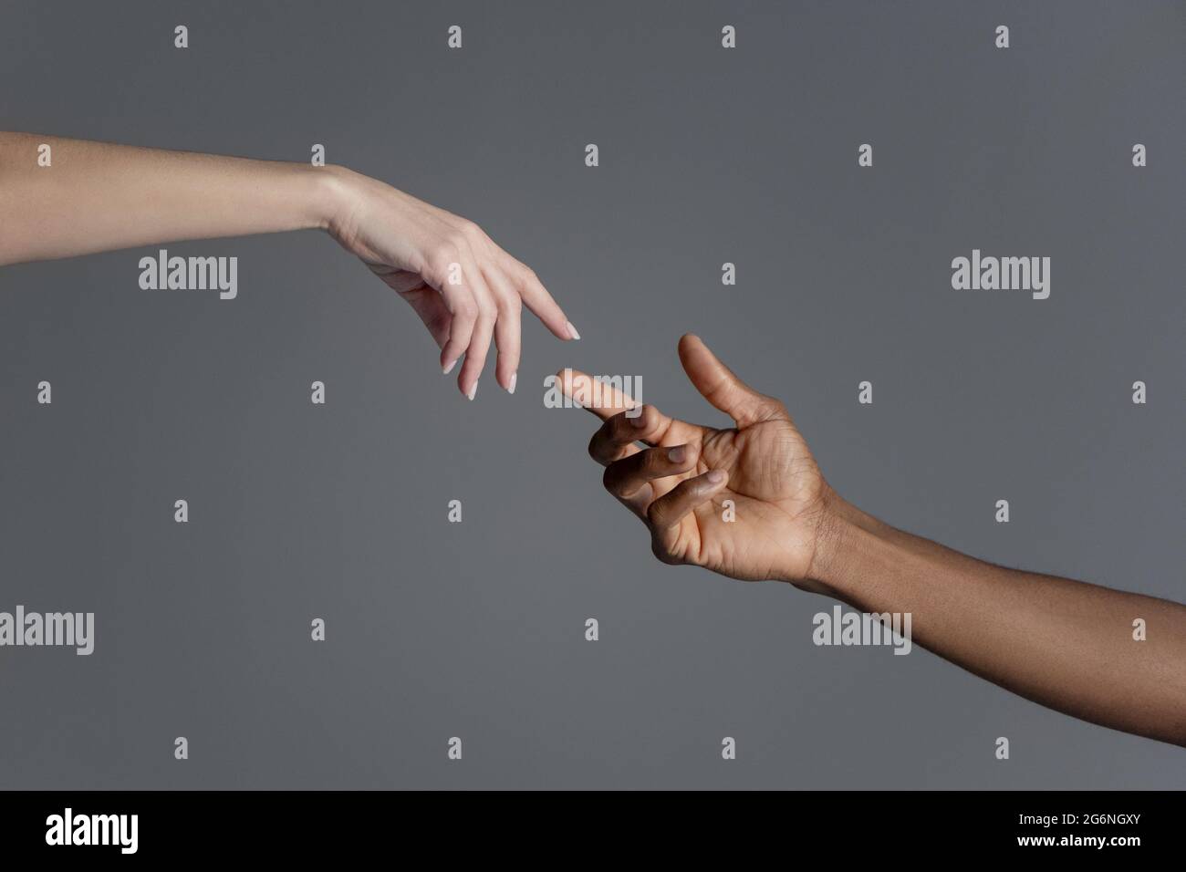 Mani maschili e femminili che si raggiungono l'un l'altro copiando la creazione del segno di Adamo. Foto Stock
