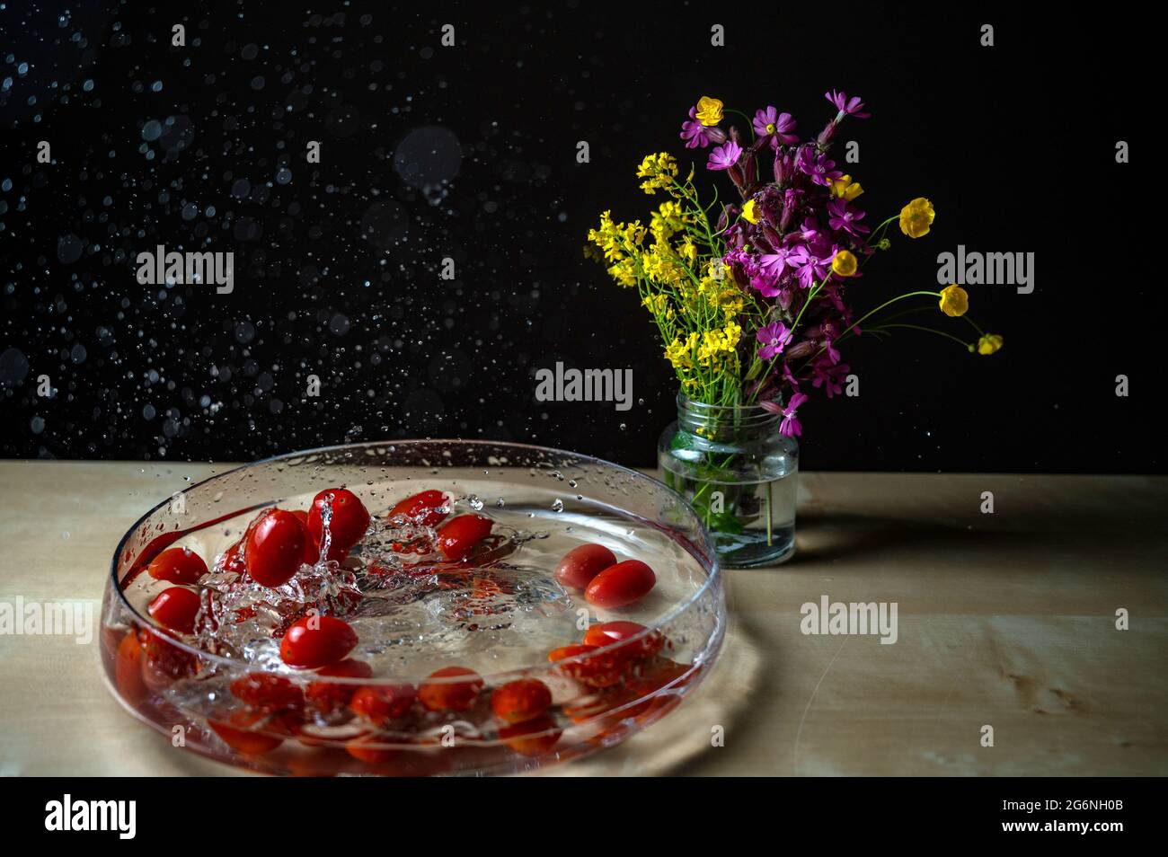 Primo piano di un gruppo di tomatos di prugne (pomodoro bambino, pomodoro ciliegia) rosso fresco che cade sul recipiente dell'acqua con acqua splash copyspace fiore backgro Foto Stock Primo piano di un gruppo di tomatos di prugne (pomodoro bambino, pomodoro ciliegia) rosso fresco che cade sul recipiente dell'acqua con acqua splash copyspace fiore backgro Foto Stock