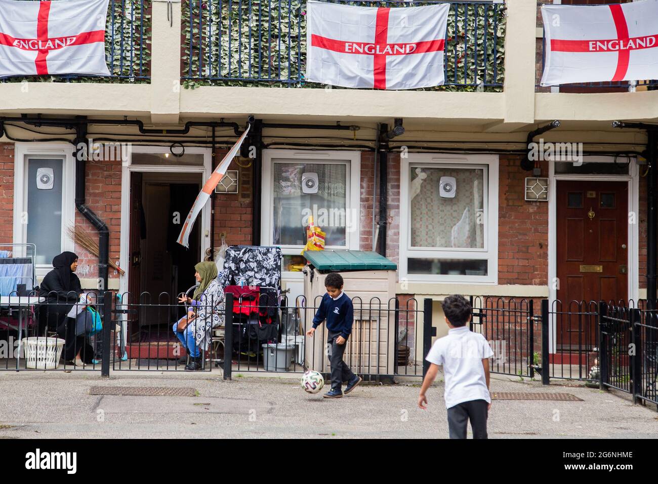 Londra, Regno Unito. 07 luglio 2021. I bambini giocano nella tenuta Kirby di Bermondsey, a sud-est di Londra. Un'abitazione è stata coperta con bandiere inglesi prima della partita semifinale contro la Danimarca. (Foto di Thabo Jaiyesimi/SOPA Images/Sipa USA) Credit: Sipa USA/Alamy Live News Foto Stock