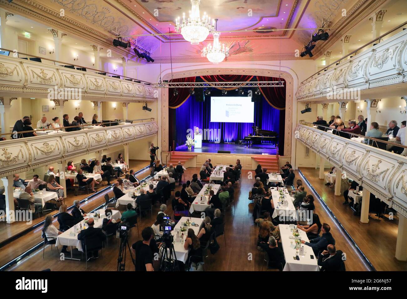 Erfurt, Germania. 07 luglio 2021. Gli spettatori siedono al Kaisersaal mentre Monika Grütters (CDU), il Ministro federale della cultura, parla alla cerimonia di premiazione del Premio tedesco per i librai. Viene assegnato in tre categorie e viene fornito con un totale di 47,000 euro in denaro premio. Per la settima volta, rende omaggio a librerie indipendenti e gestite da proprietari in tutta la Germania, particolarmente impegnate nei libri come patrimonio culturale, in una vivace offerta culturale locale o in una gamma diversificata di prodotti editoriali. Credit: Bodo Schackow/dpa-Zentralbild/dpa/Alamy Live News Foto Stock