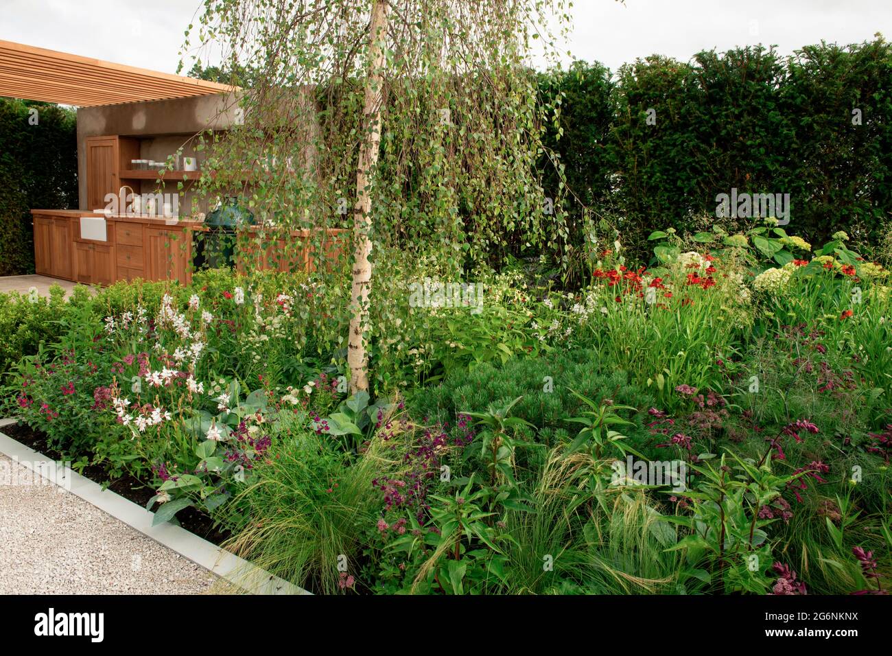 Una cucina all'aperto circondata da piante nel Giardino Viking Friluftsliv all'Hampton Court Palace Garden Festival 2021 Foto Stock