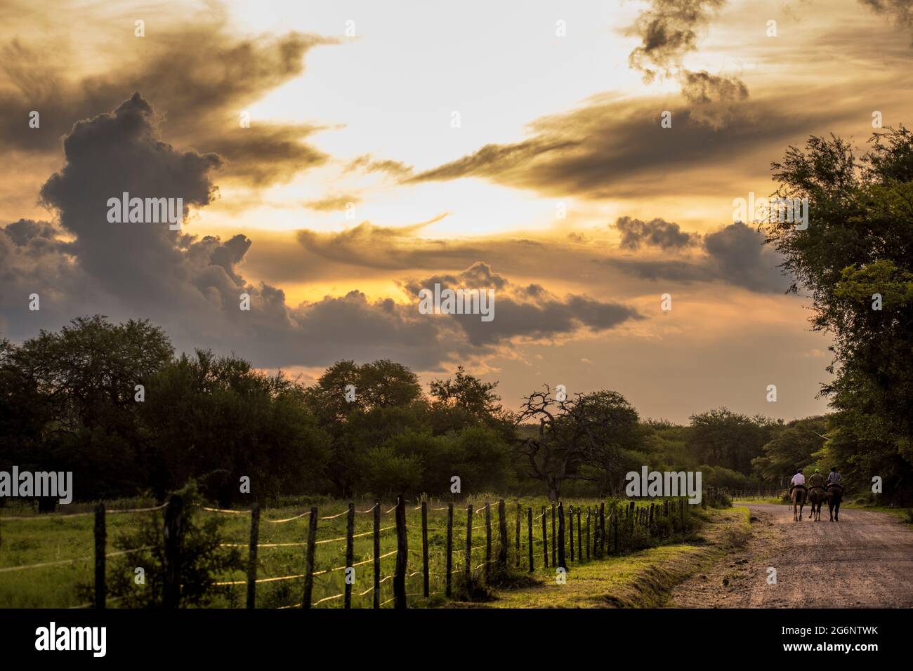 Tre piloti in una strada sterrata con un cielo molto espressivo a Córdoba, Argentina Foto Stock