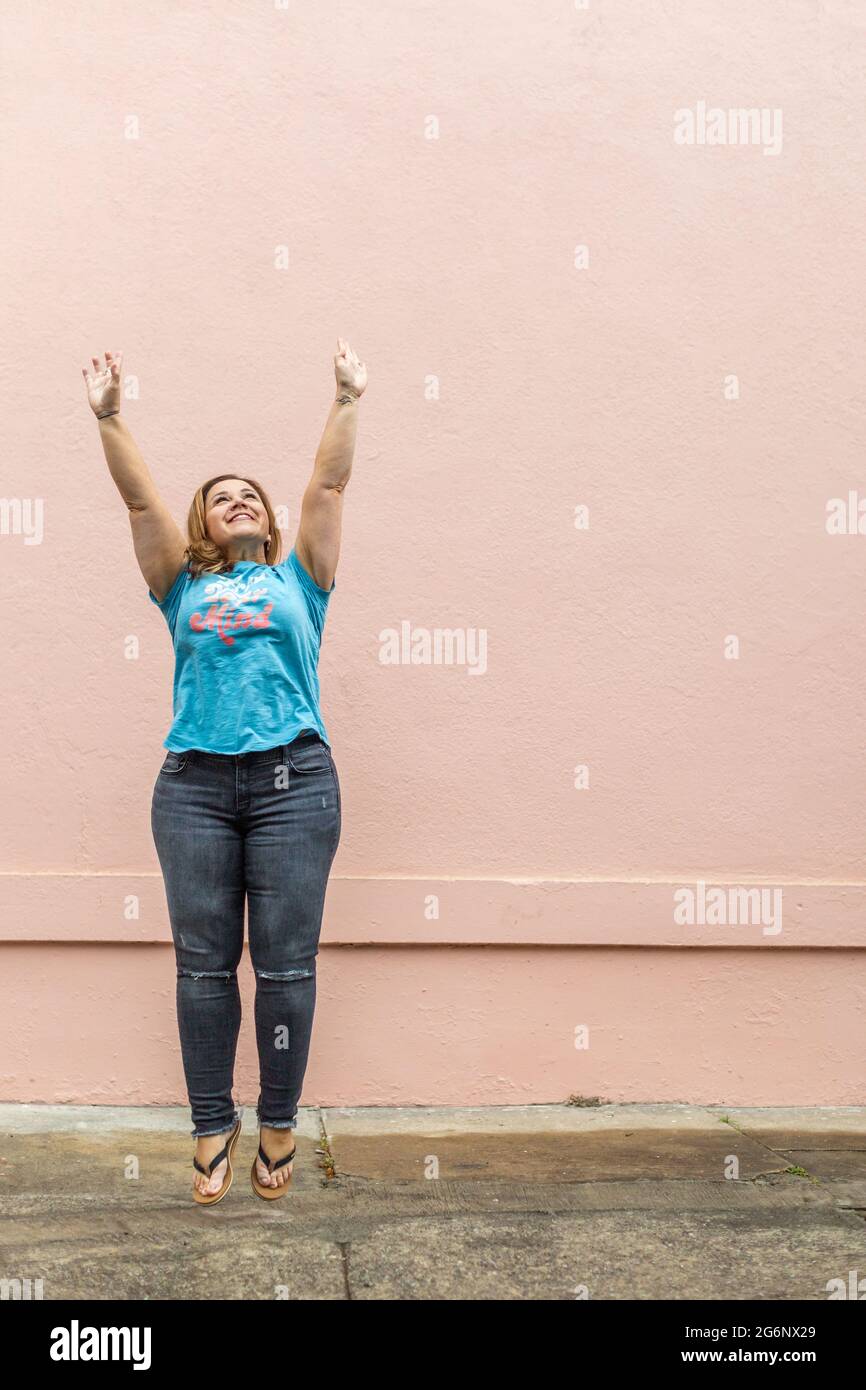 un'immagine di salto a lunghezza intera di una donna in una t-shirt libera la tua mente con jeans Foto Stock