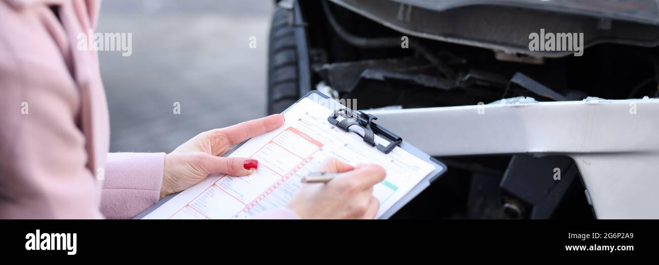 Un agente assicurativo descrive i danni al veicolo a motore Foto Stock