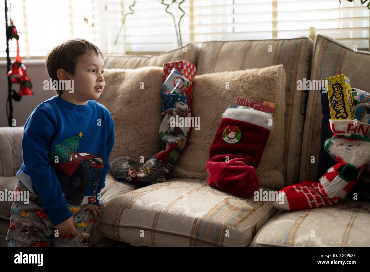 Un ragazzino sta per aprire la sua calza di Natale Foto Stock