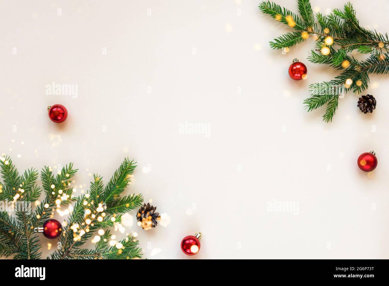 Natale sfondo festivo rami di abete e palline di Natale rosso su sfondo beige. Vista dall'alto, disposizione piatta, spazio per la copia Foto Stock