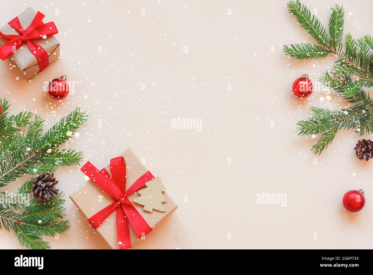 Due regali e rami di abete verde con decorazioni su sfondo beige. Concetto di Natale. Vista dall'alto, disposizione piatta, spazio per la copia Foto Stock