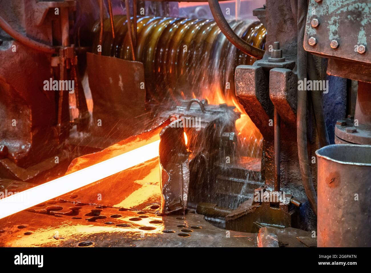 Il laminatoio in funzione. Il metallo caldo viene fatto rotolare attraverso rulli raffreddati Foto Stock