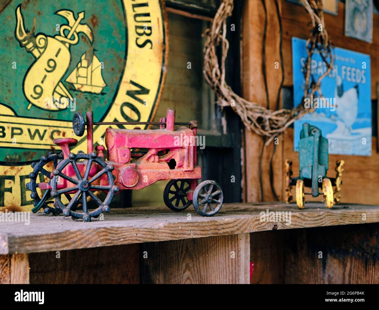 Vecchio trattore giocattolo d'epoca in metallo su un ripiano polveroso. Foto Stock