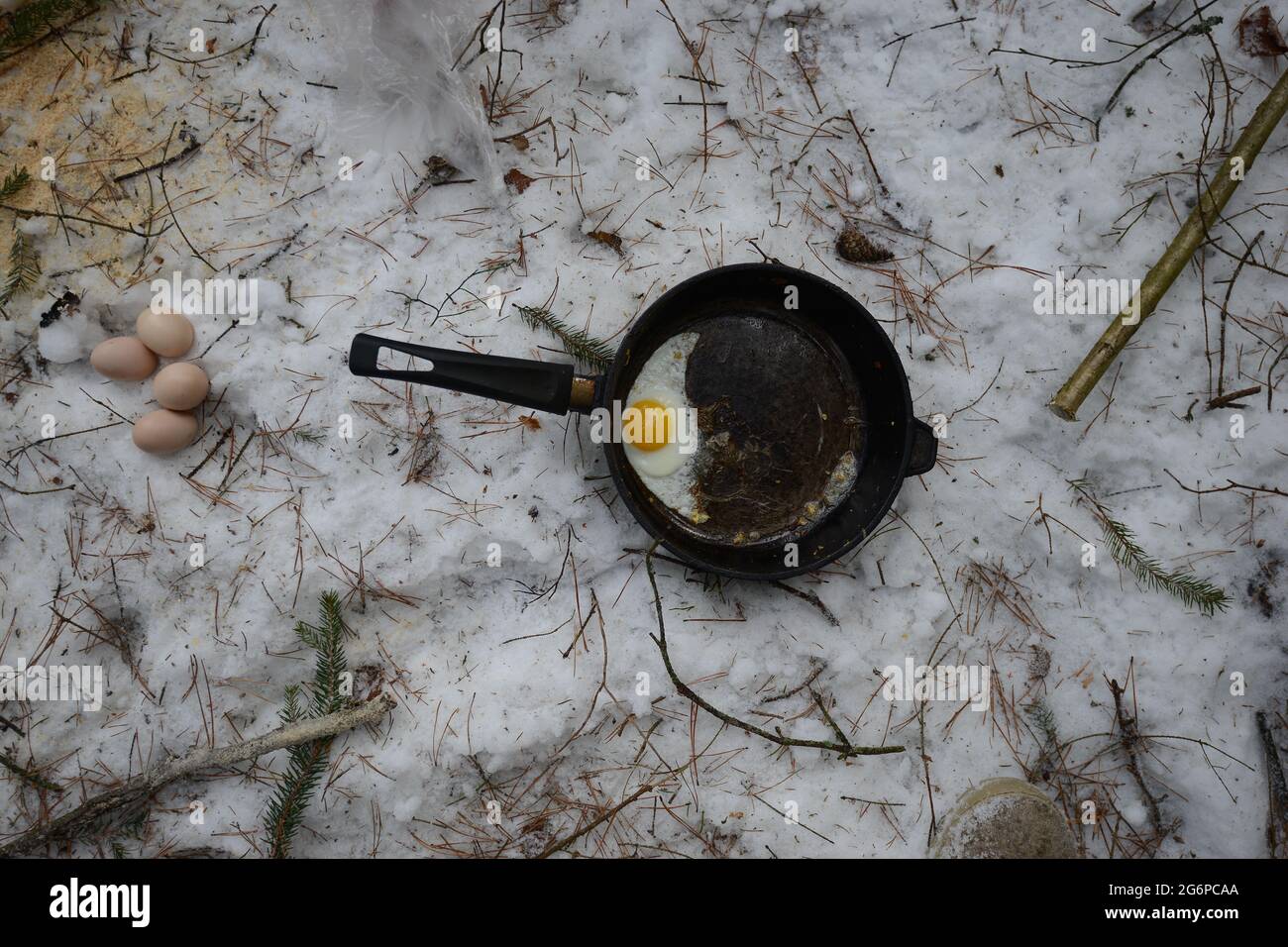 Bielorussia - 02.02.2015 - uova strapazzate nella padella nella foresta invernale, pranzo di lumberjack. Foto Stock