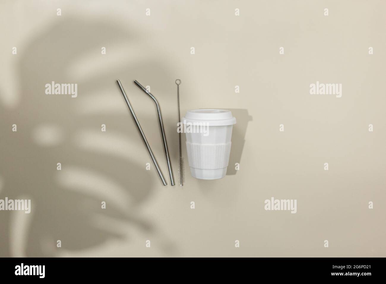 Tazza di caffè bianca e tubi metallici per bevande su sfondo beige. Shopping ecocompatibile. Primo piano. Zero rifiuti alimentari concetto. Stile di vita sostenibile Foto Stock