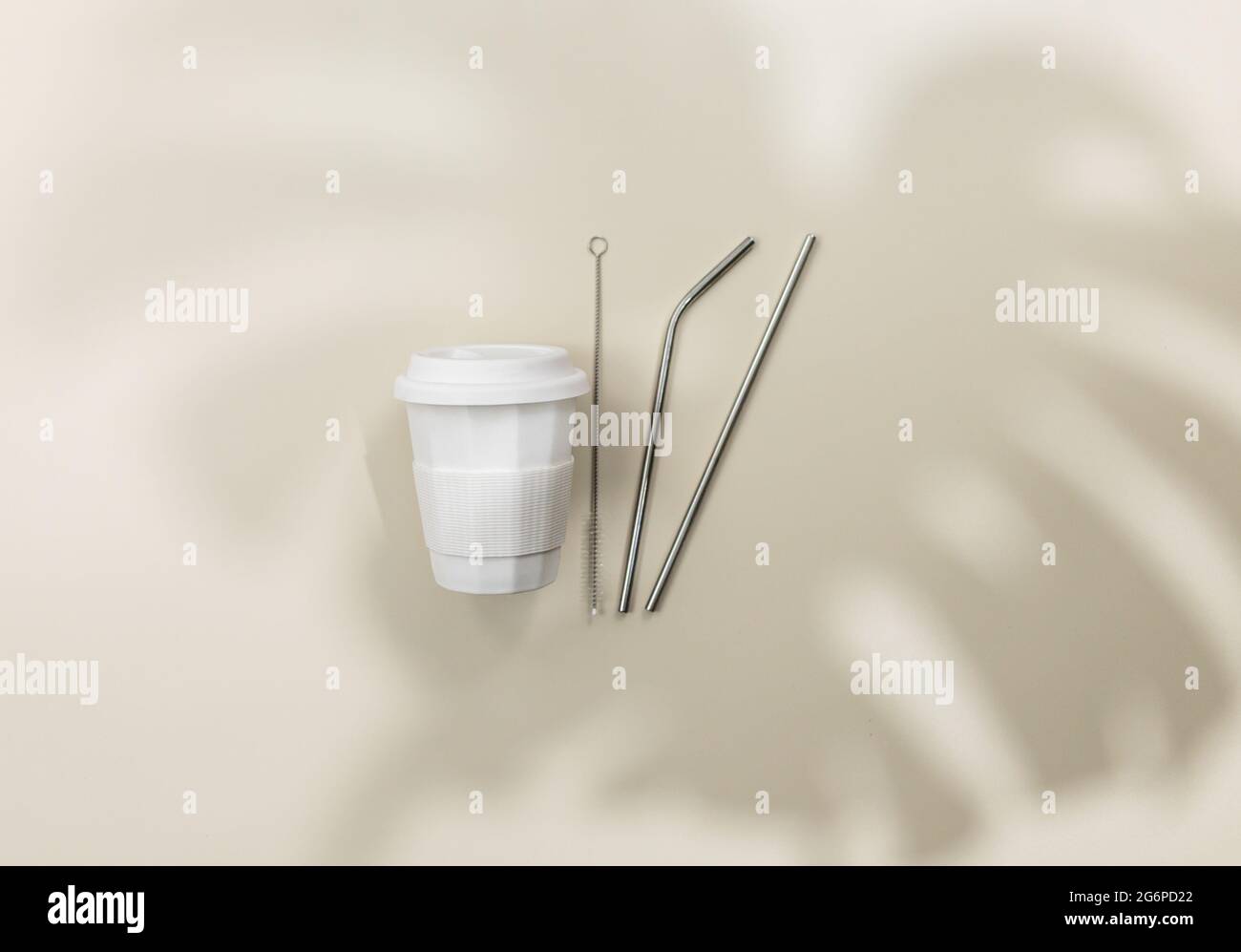 Tazza di caffè bianca e tubi metallici per bevande su sfondo beige. Shopping ecocompatibile. Primo piano. Zero rifiuti alimentari concetto. Stile di vita sostenibile Foto Stock