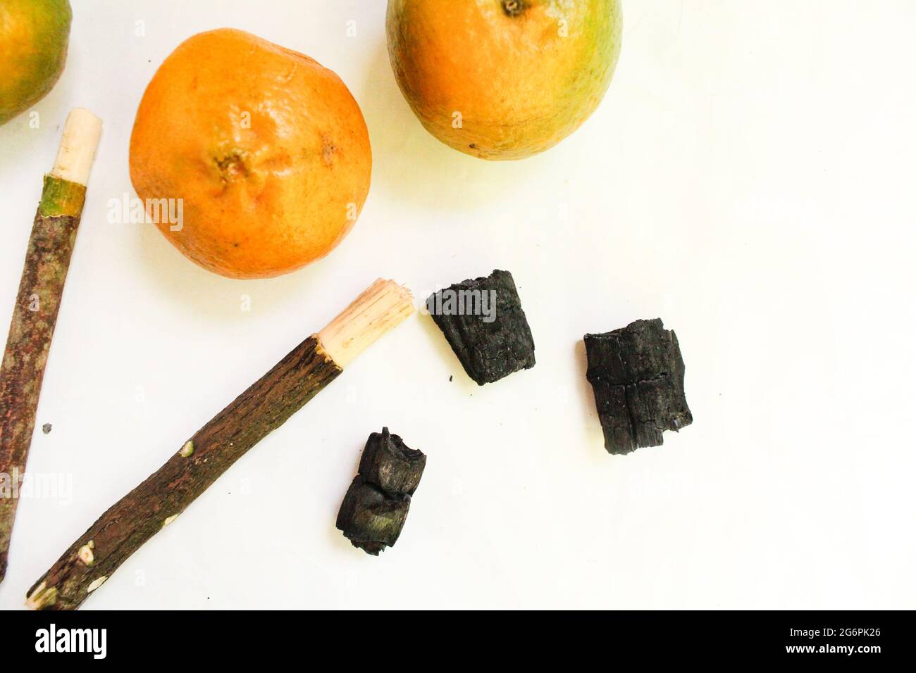 Bastone Miswak con arancio su superficie bianca, miswak per denti migliori e musulmani Foto Stock
