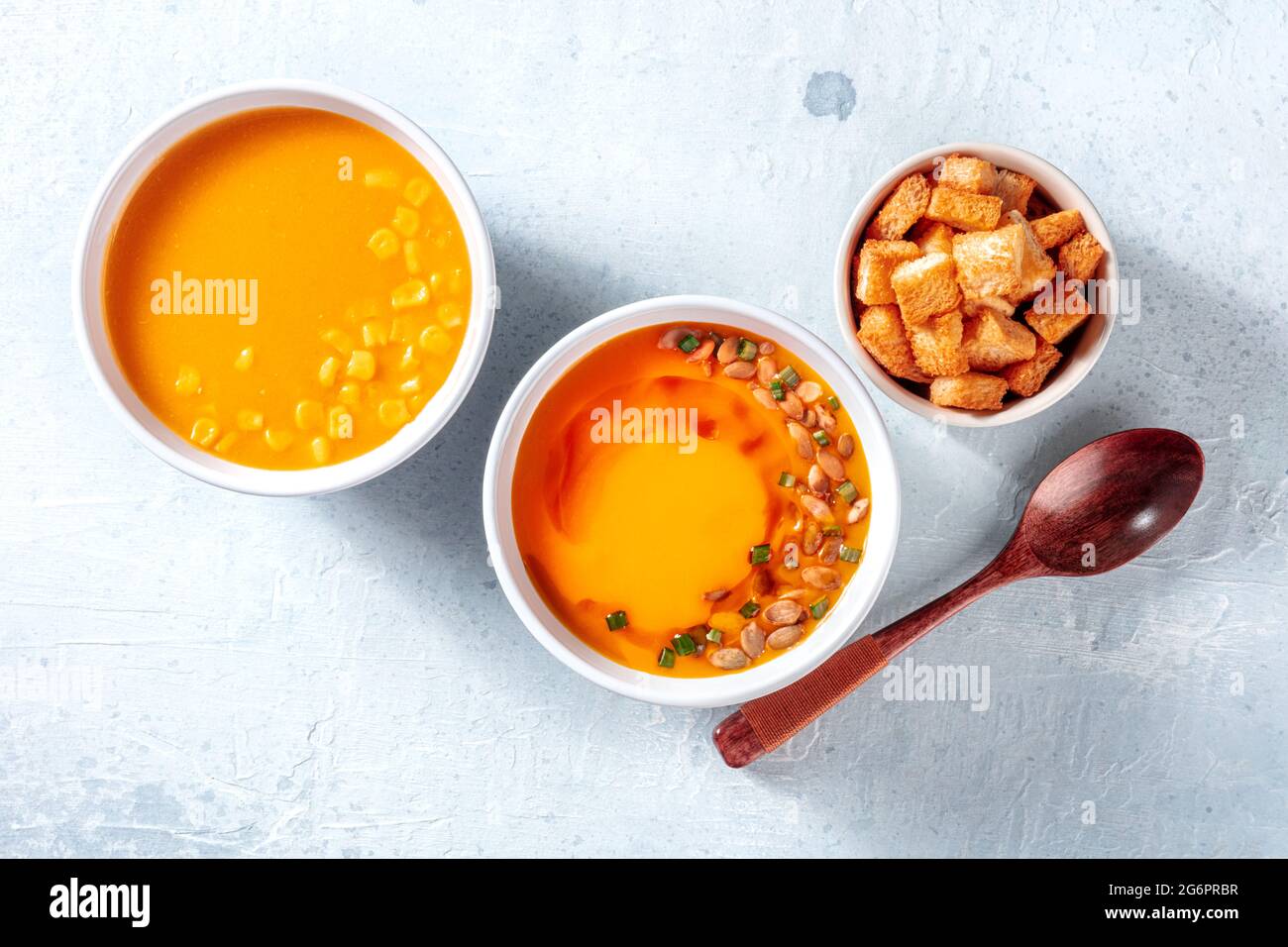 Zuppa vegana, crostini e un cucchiaio, sparati dall'alto. Zuppe di zucca e crema di mais, sano pasto vegan detox Foto Stock