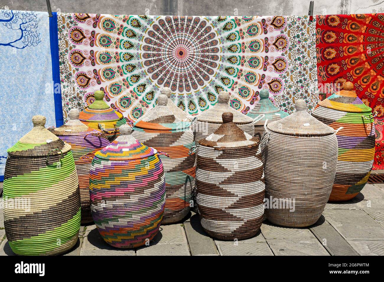 Primo piano di un gruppo di cesti in tessuto multicolore con tessuti stampati sullo sfondo in vendita in un mercato di strada, Genova, Liguria, Italia Foto Stock