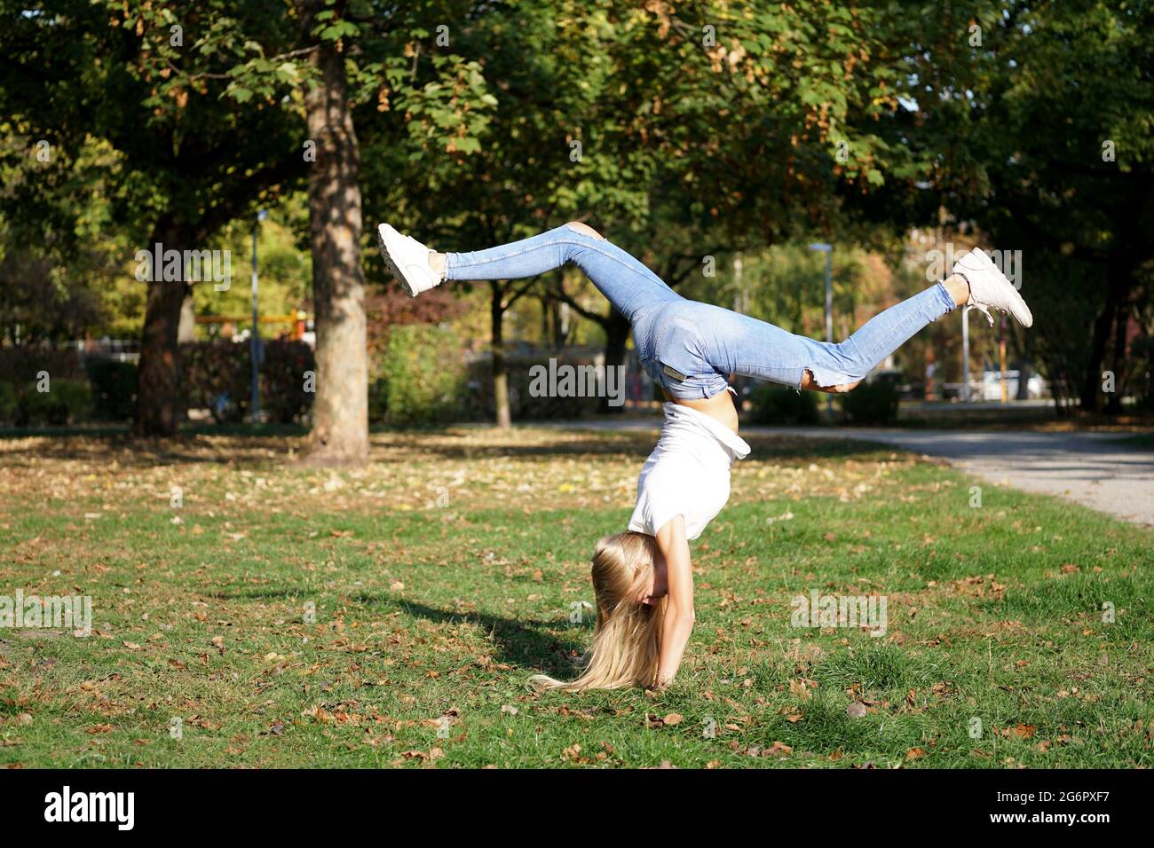 la ragazza che pratica il handstand in un parco Foto Stock