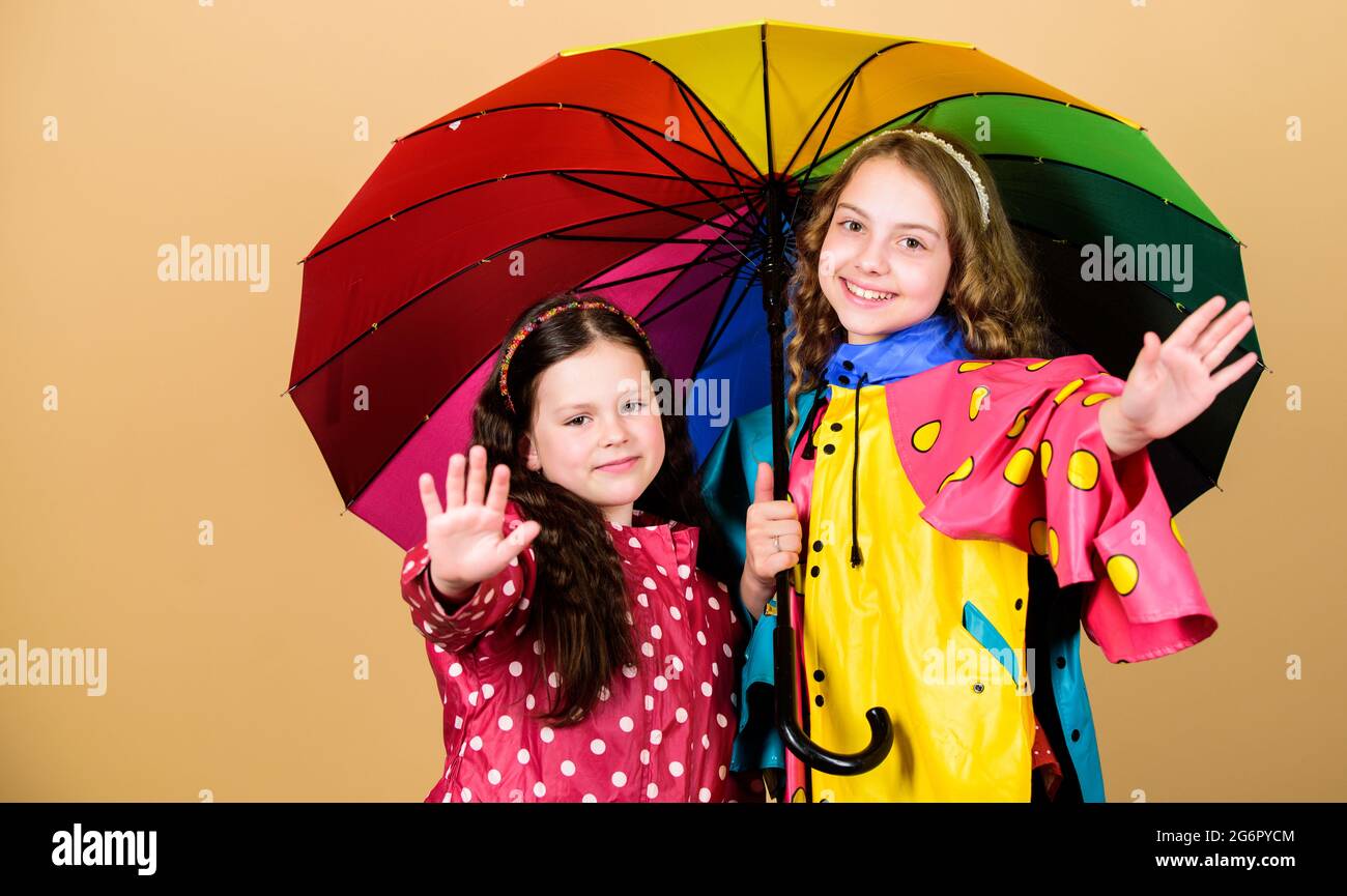 legami familiari. Bambine in impermeabile. Ragazze felici con ombrello  colorato. Protezione contro la pioggia. Arcobaleno. Moda autunnale. Allegri  hipster bambini Foto stock - Alamy