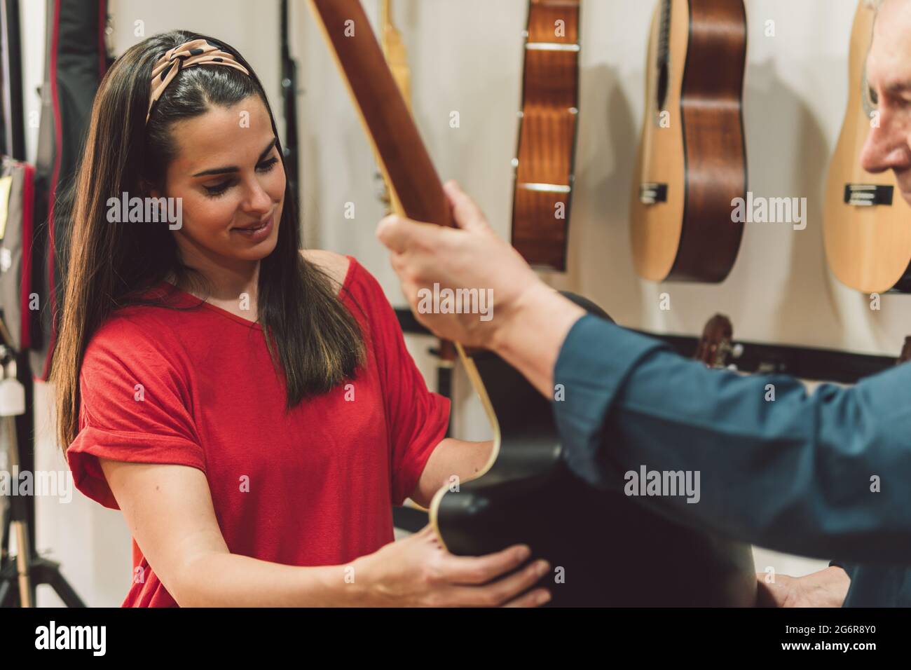 Venditore che mostra una chitarra ad una donna Foto Stock